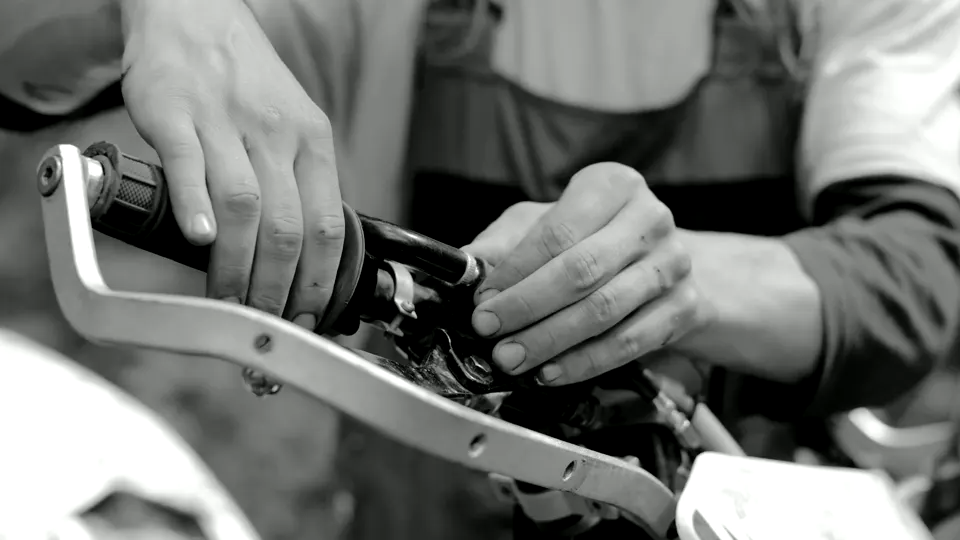 A person carefully repairing a motorcycle component